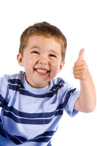 Smiling boy giving thumbs up