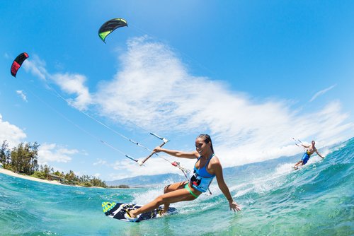 woman kitesurfing in turquoise water at Kanaha Beach Maui