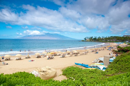 ulua beach on Maui with blue sky and cabanas on sand